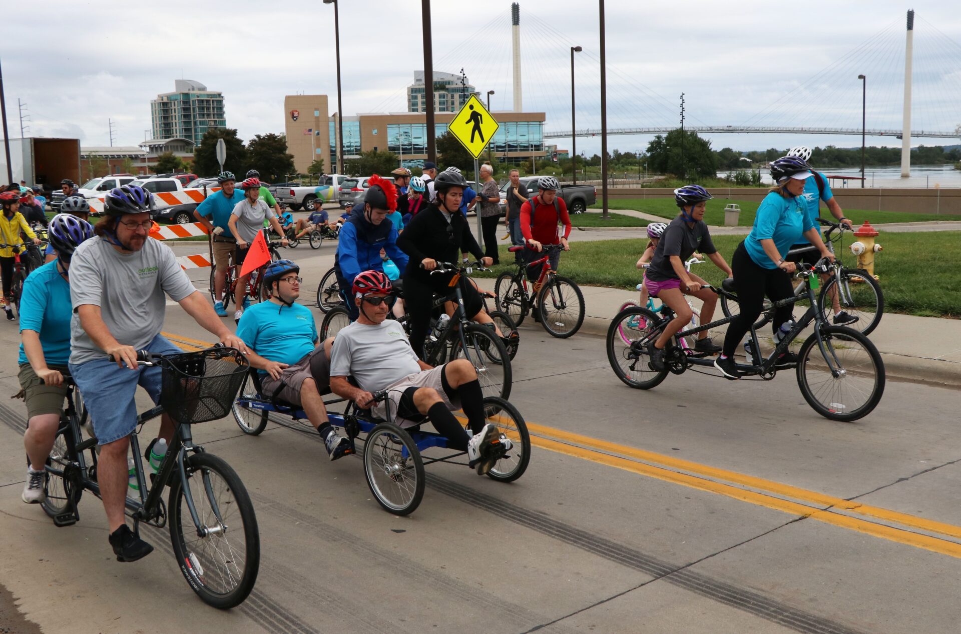 Tandem bikes and bikers in the street at the start line for the Corporate Cycling Challenge.