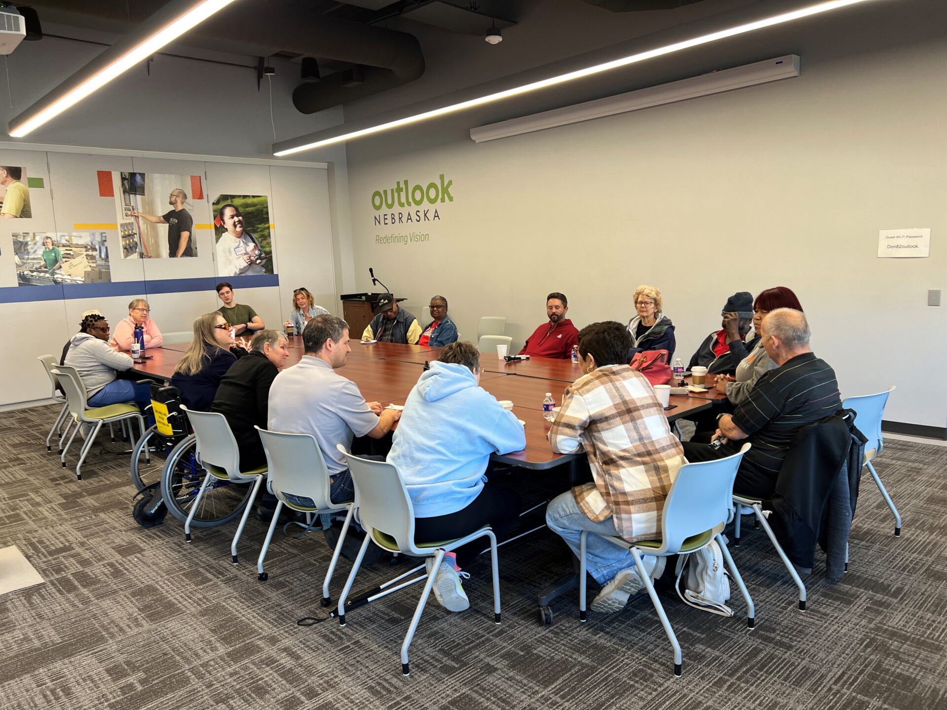 A group of about 14 people sitting around a long rectangle table at Outlook Nebraska.