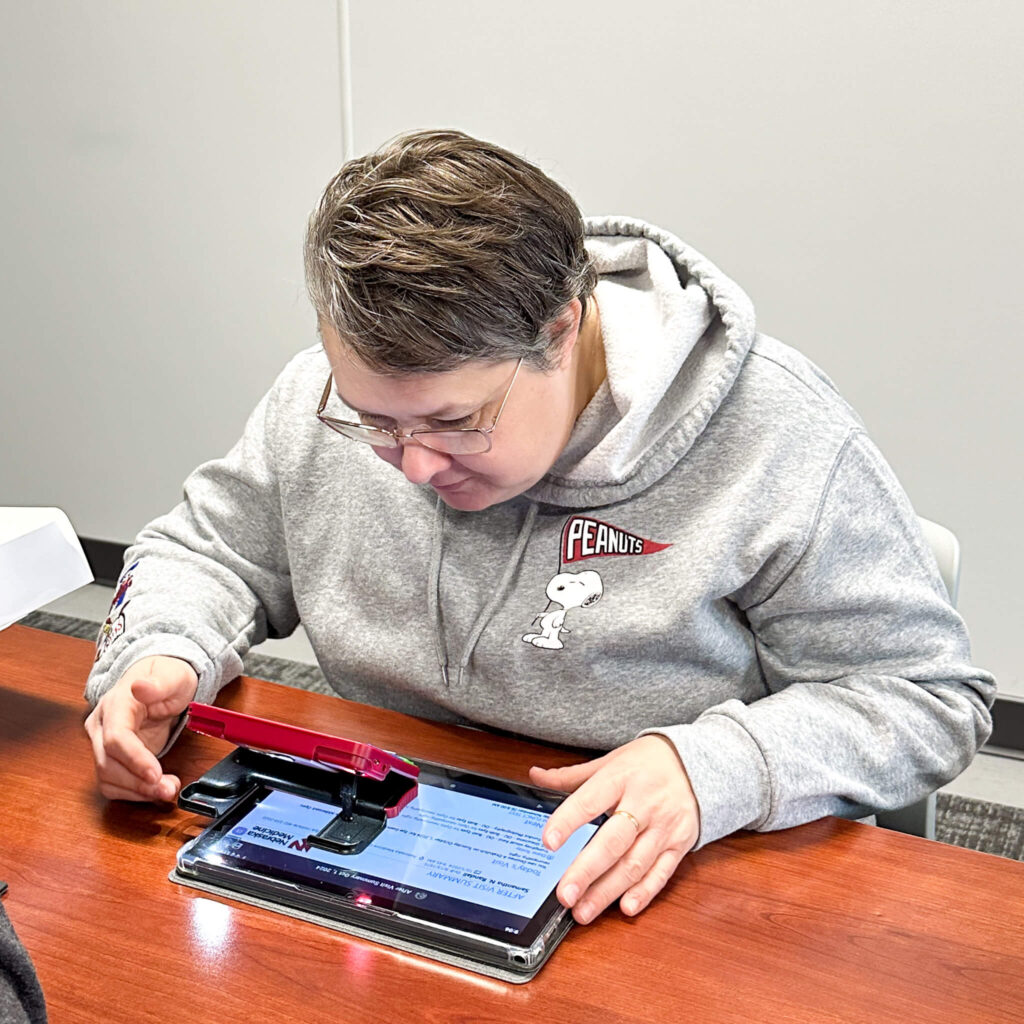 Visually impaired woman using adaptive technology on a phone and ipad