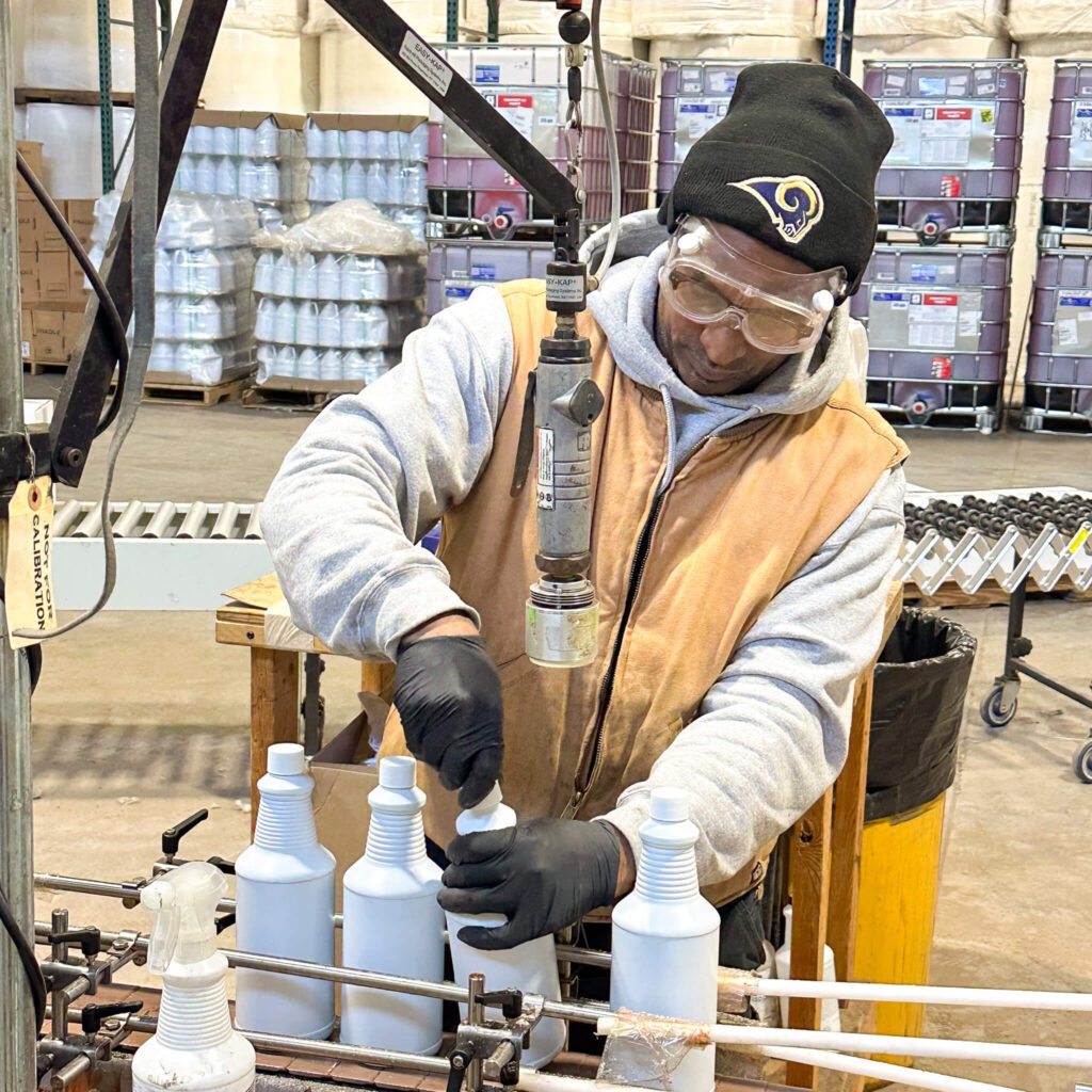 A man wearing a black beanie inspects cleaner products