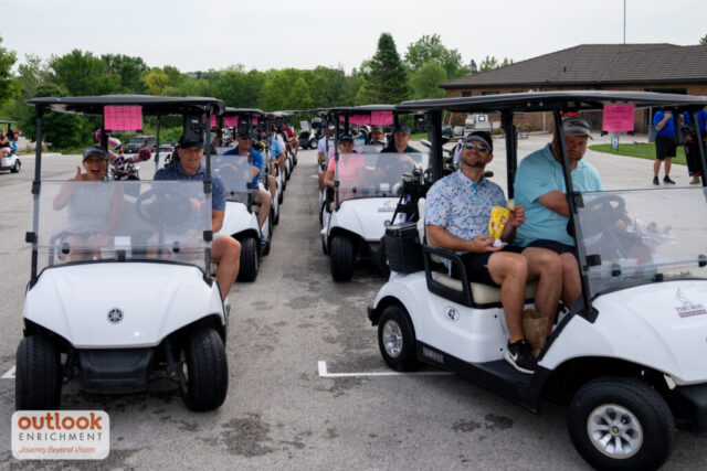 Golf carts with teams getting ready to head to the course.