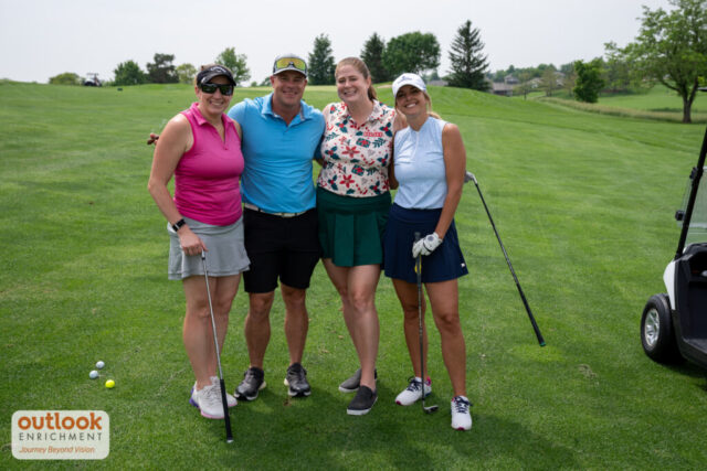 3 ladies and 1 man smiling on the course.