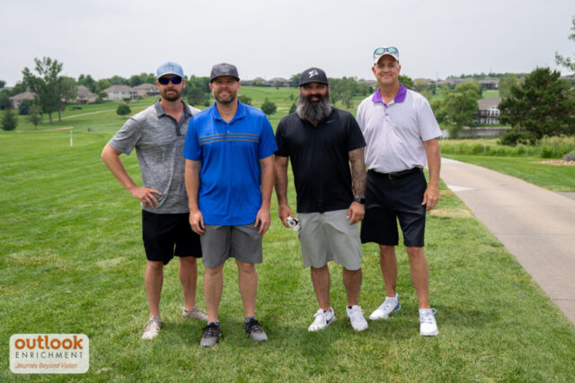4 men smiling for a photo.