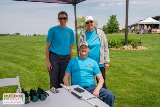 Volunteers smiling for a photo. 1 man and two women.