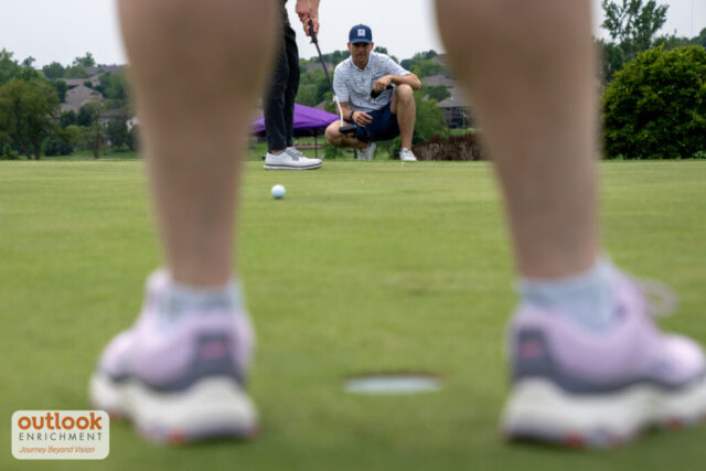 A shot of a man watching his putt on a ground level view.