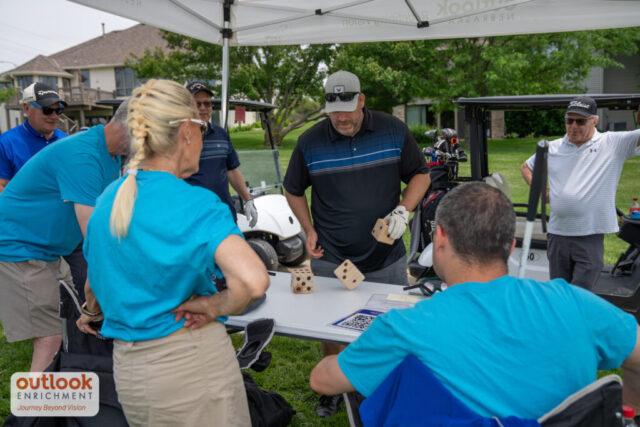 A man rolling dice for a hole challenge.
