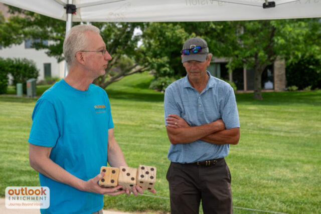 A male volunteer giving instruction for dice hole challenge.