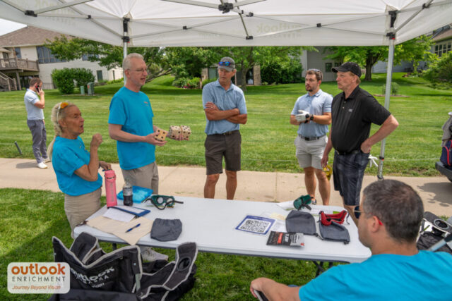 A male volunteer giving instruction for dice hole challenge.