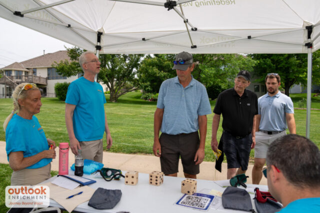 A man rolling dice for a hole game.