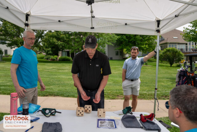 A man rolling dice for a hole game.