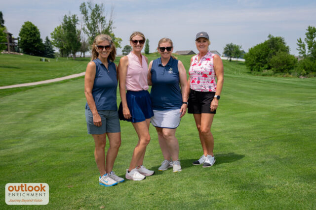 4 ladies smiling on the course.