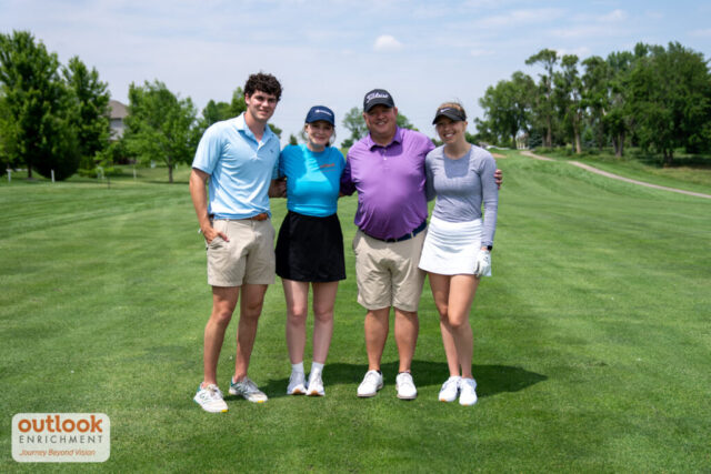 2 women and 2 men smiling on the course.