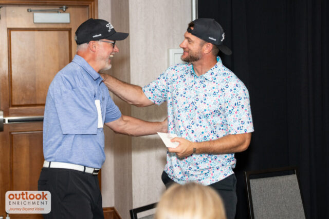Two men shaking hands at teh banquet.