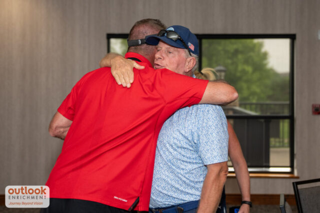 2 men hugging at the banquet.
