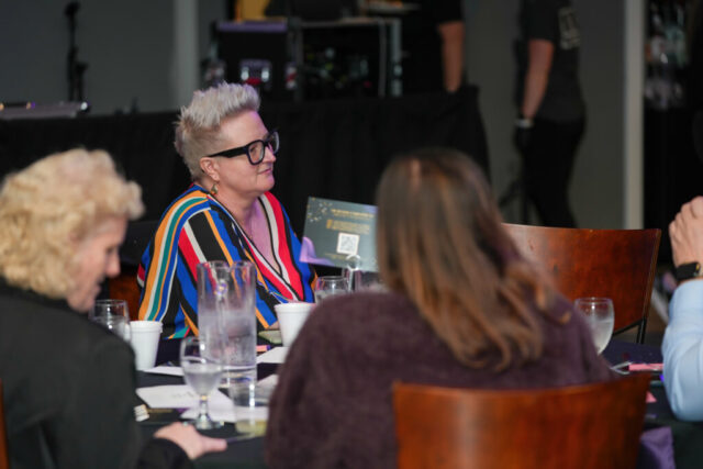 A woman is looking across the table.
