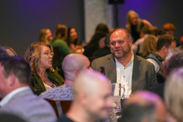 A man and a woman talking at their table.