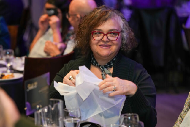 A woman putting her bib on.