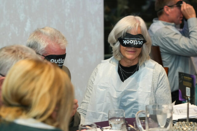 A woman wearing her sleep shades upside down and a bib.