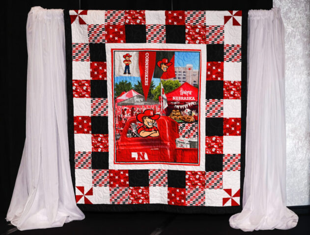 A husker quilt being displayed on stage.