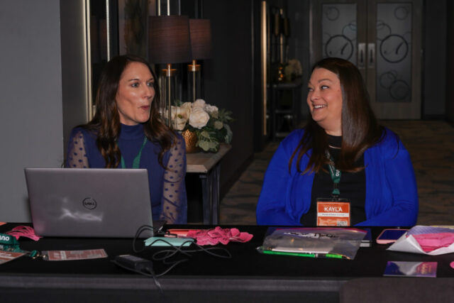 Two woman volunteers talking and the entrance.