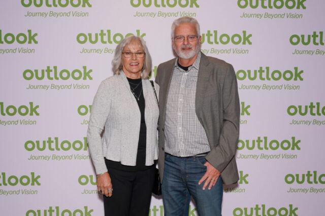 The Hales smiling in front of an Outlook backdrop.
