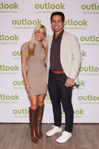 Jenny and a man smiling in front of an Outlook backdrop.