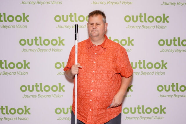 Mickie in front of an Outlook backdrop.