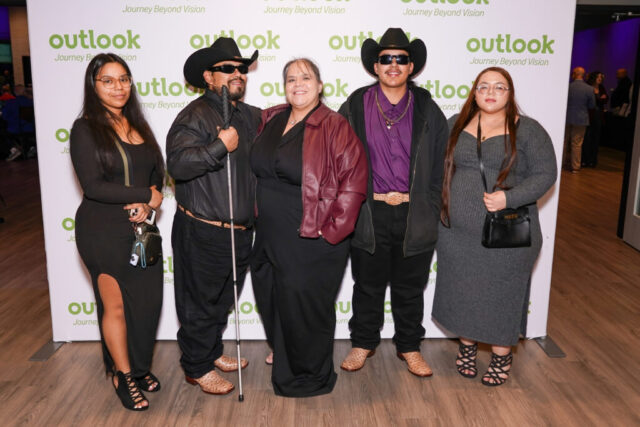 Willie and her guests are smiling in front of an Outlook backdrop.
