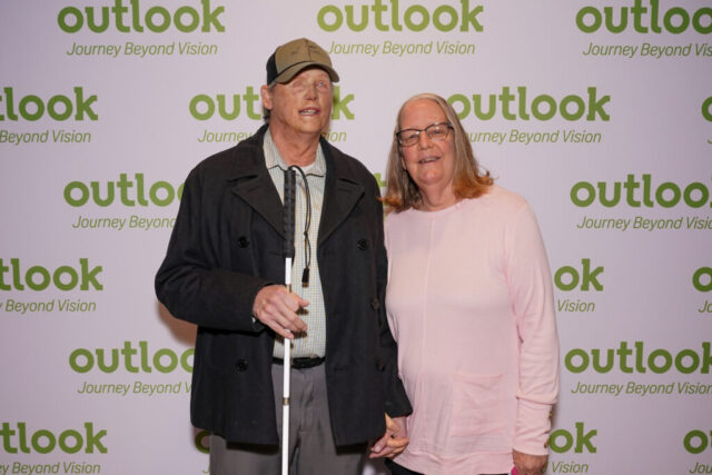 Mark and Bertie are smiling in front of an Outlook backdrop.