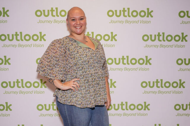Tea is smiling in front of an Outlook backdrop.
