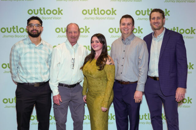 Montage Builders table smiling in front of an Outlook backdrop.