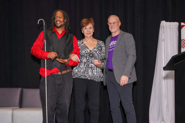 Associates of the Year, Mortel and Morie are smiling with Eric.