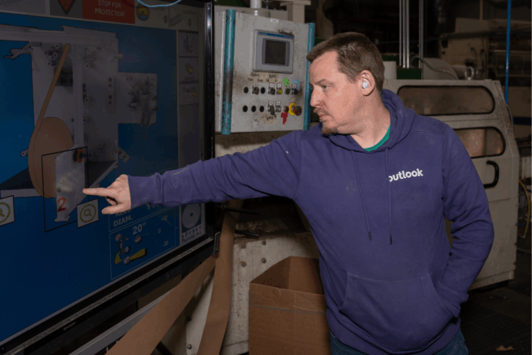 Josh Scarborough is working on the manufacturing floor, touching a large screen.