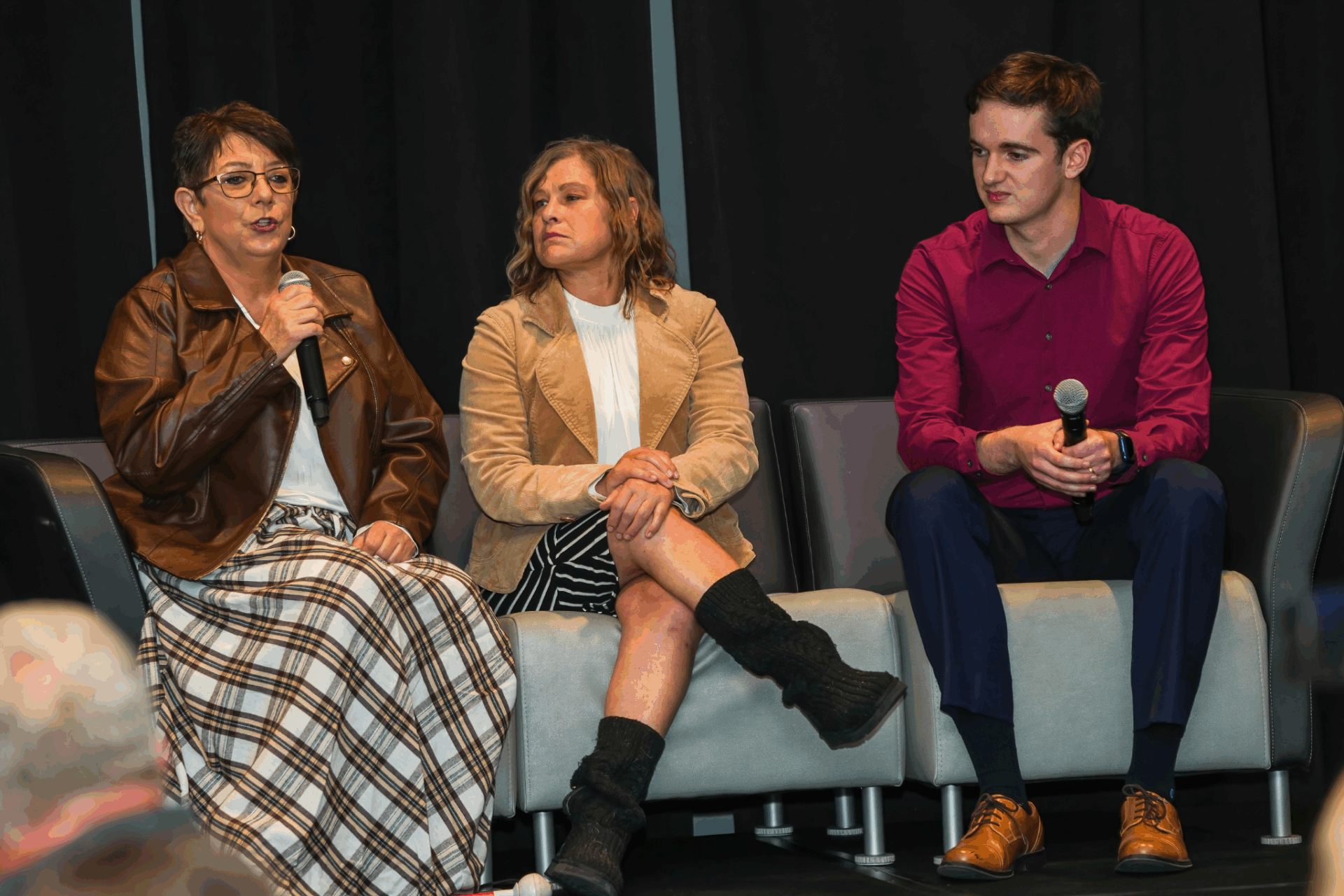Rondae, Megan, and Isaac are sitting on a couch on stage at VBS. Rondae is speaking.