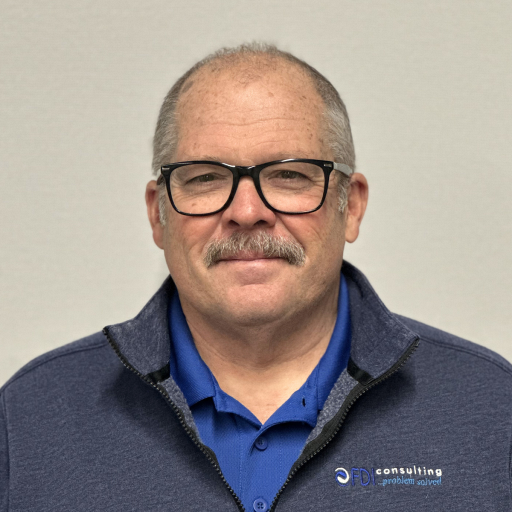 Dave Fulton, member of Outlook Enrichment, wearing a blue polo shirt and gray jacket with FDI Consulting logo, smiling against a neutral background.