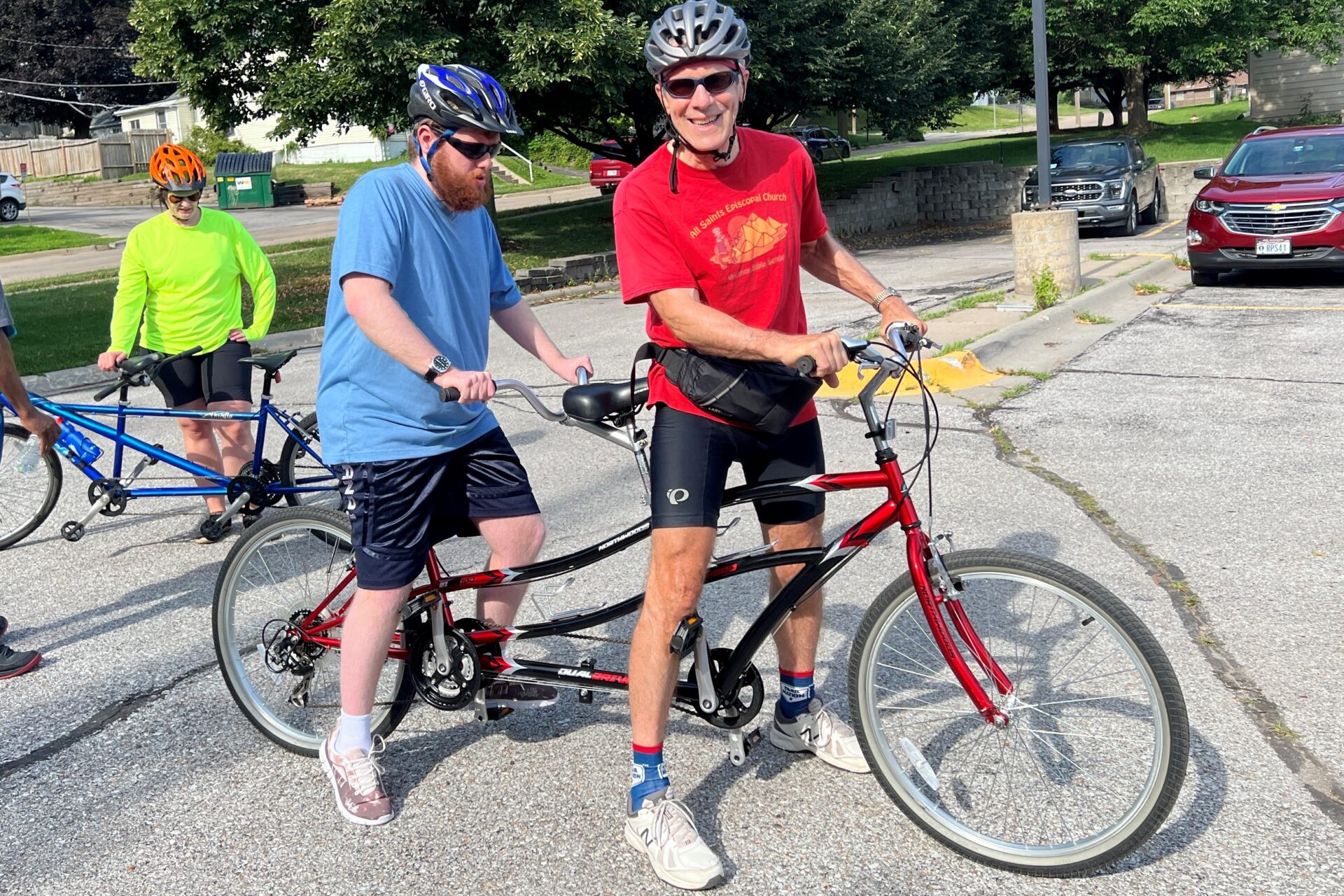 Rob and Alex wearing helmets and riding a standard tandem bike