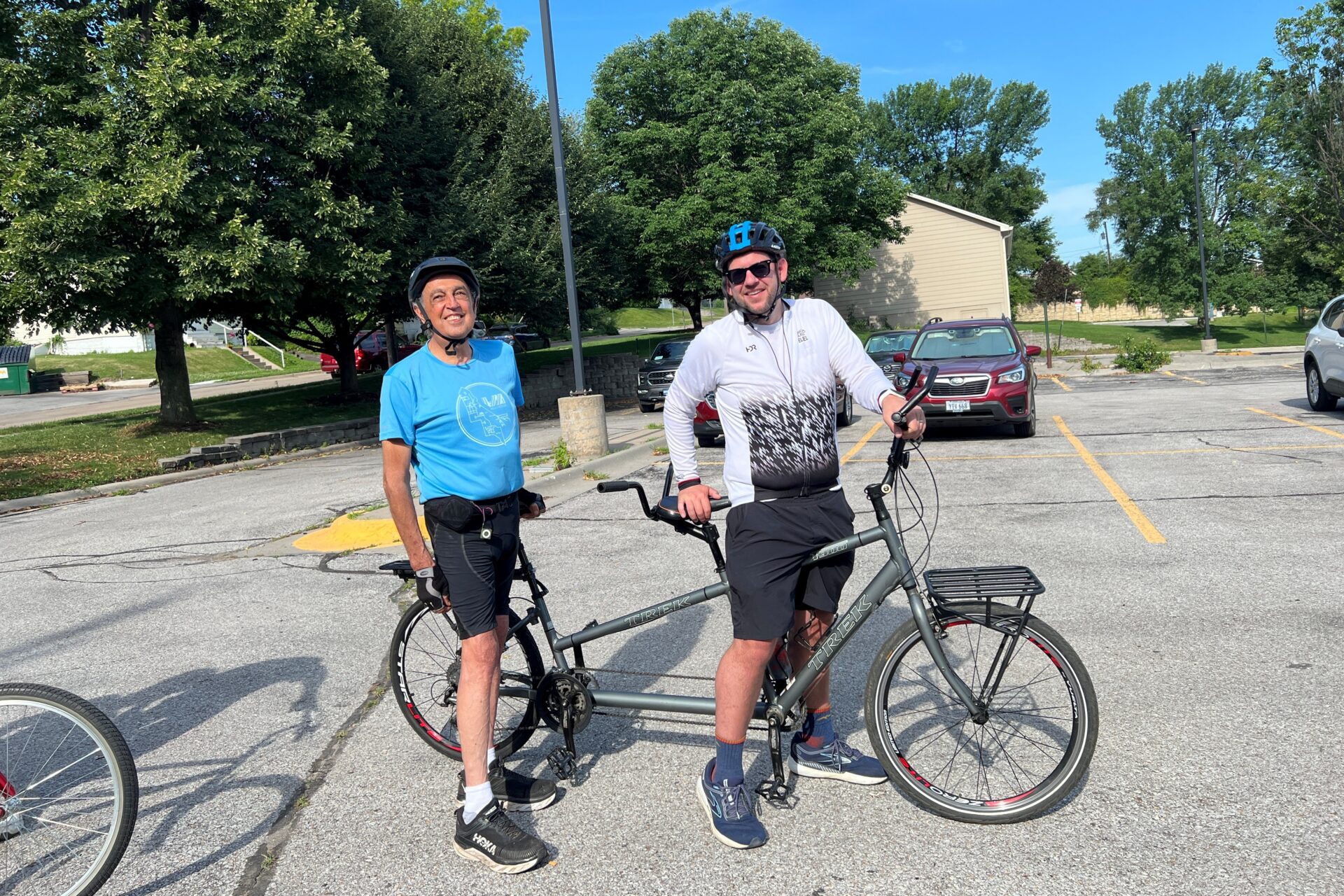 Two men on a standard tandem bike taking off for a ride