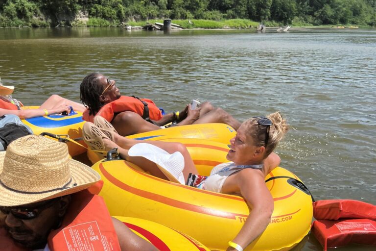Megan and Mortel lating in yellow round inner tubes floating down the river.