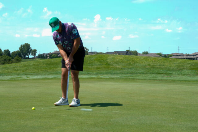 A man is putting on the green.