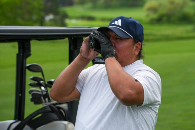 A man is looking through a rangefinder.