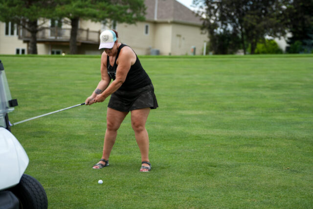Marisa is swinging her club.