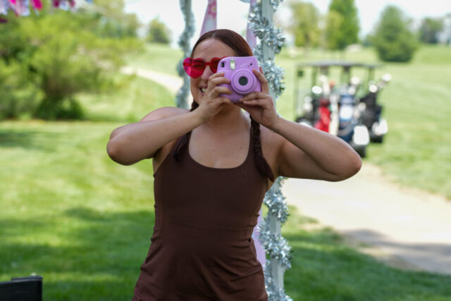 Jenny looking through a polaroid camera.