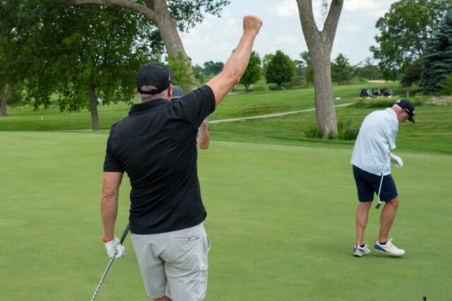 A man is doing a fist pump.