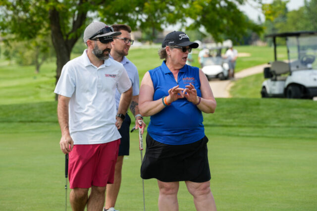 Susanne and two men on the blind putt hole.