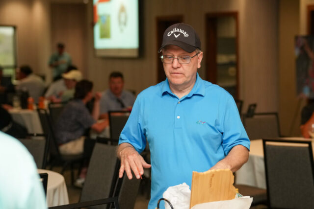 A man is looking at a raffle prize.