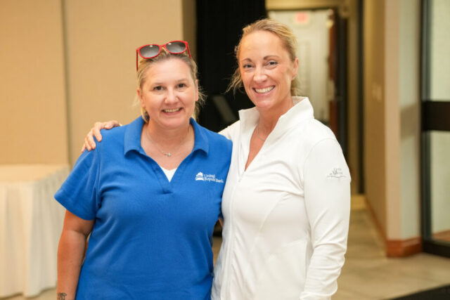 A lady from United Republic Bank and another are smiling.