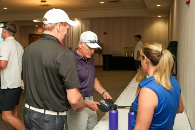 Nina is talking to two men looking at Outlook gear.