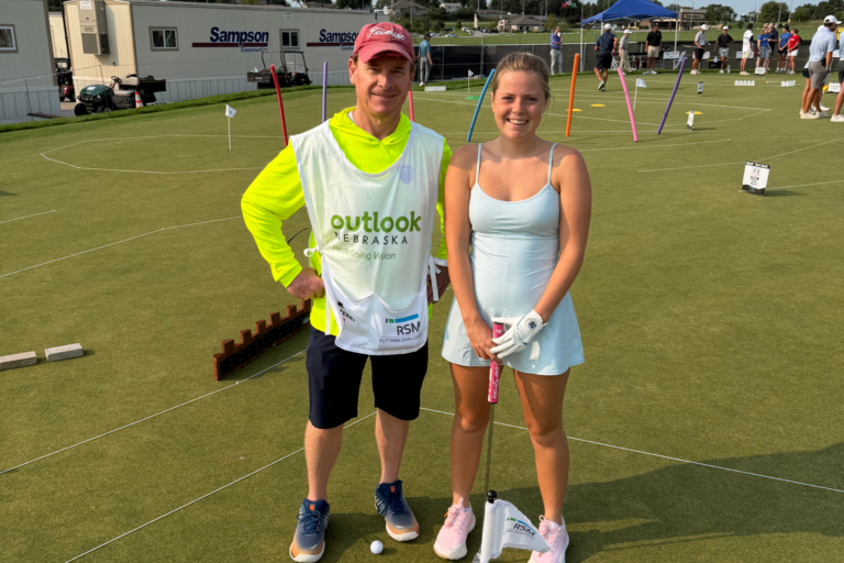 Anna Weber and Steve Blaskovich smile together on the course during the RSM Putting Challenge.