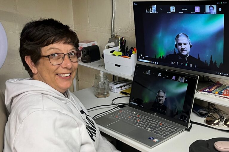 Rondae is wearing glasses, sitting at her desk with a computer during a virtual support group meeting.